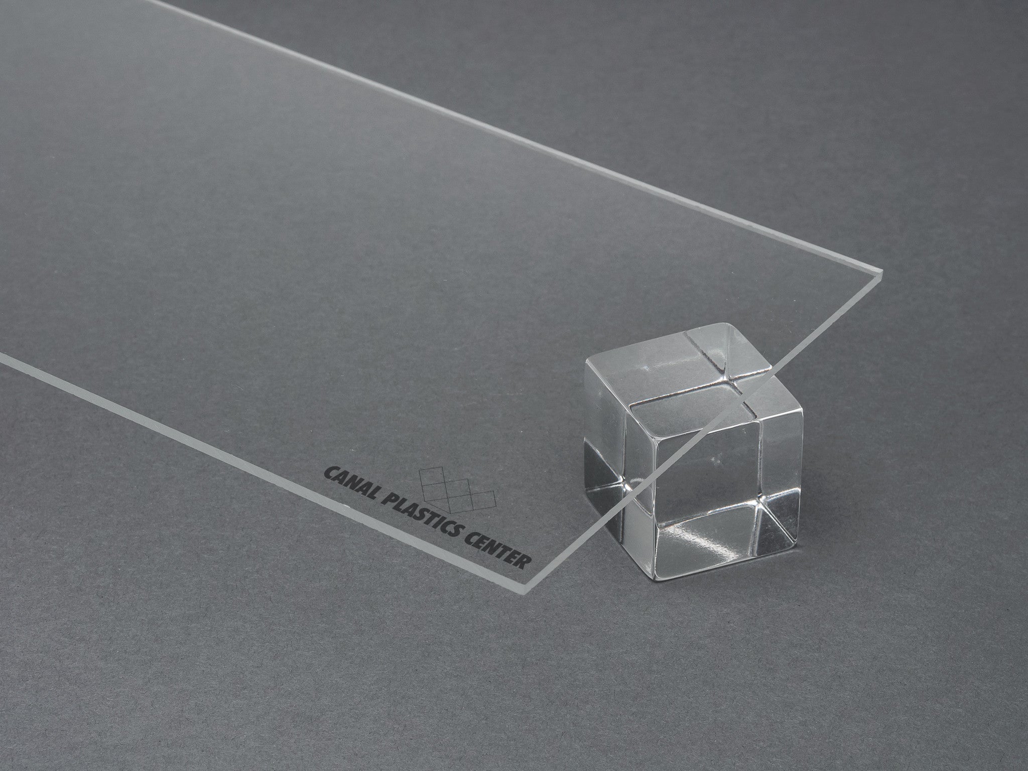 Clear cast acrylic sheet with glossy transparent surface on neutral background. Canal Plastics