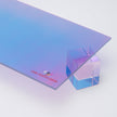 Aura Iridescent Acrylic Sheet by Canal Plastics Center: cool blue to magenta gradient with reflective film and transparent edge resting on acrylic cube