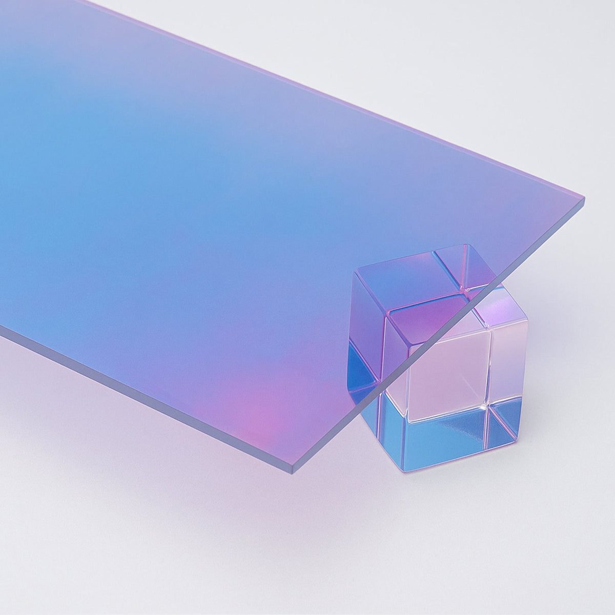Aura Iridescent Acrylic Sheet by Canal Plastics Center: cool blue to gold to magenta gradient with reflective film and transparent edge resting on acrylic cube