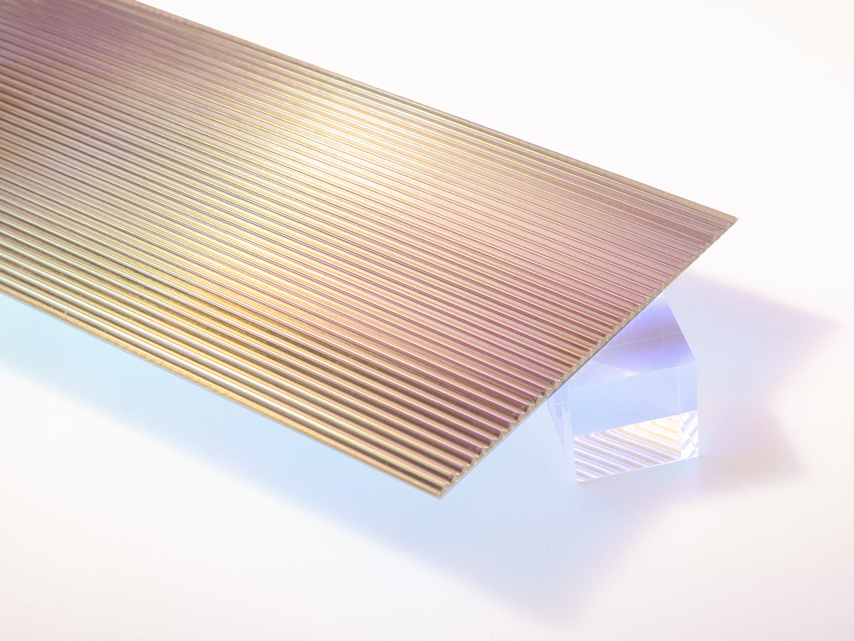 Iridescent fluted acrylic sheet, ribbed face with a color shifting film on the flat back
