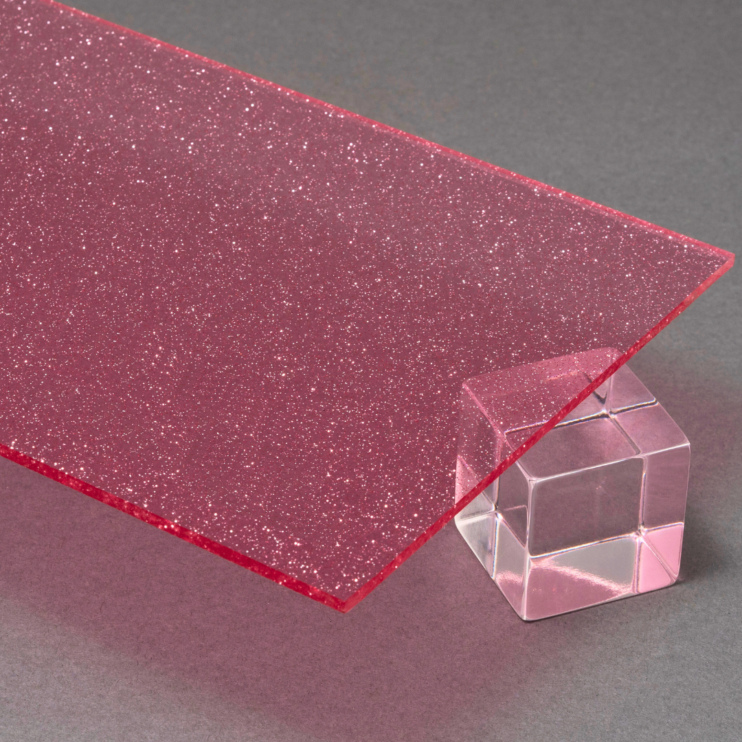 Pink glittery acrylic sheet with a clear cube on a gray background